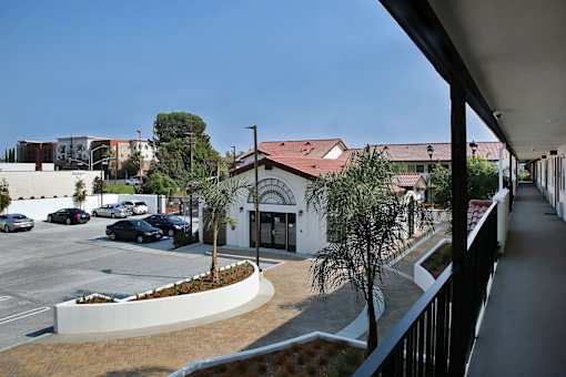 A parking lot with cars and a building with a red roof.