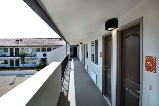 A long hallway with doors on both sides and a sign on the wall.