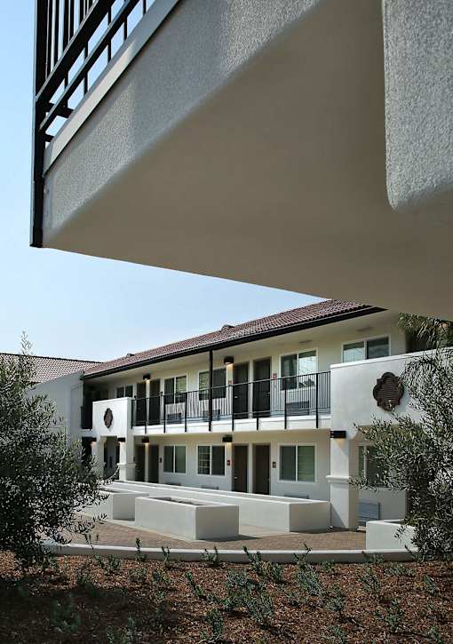 A white building with a balcony and a black railing.