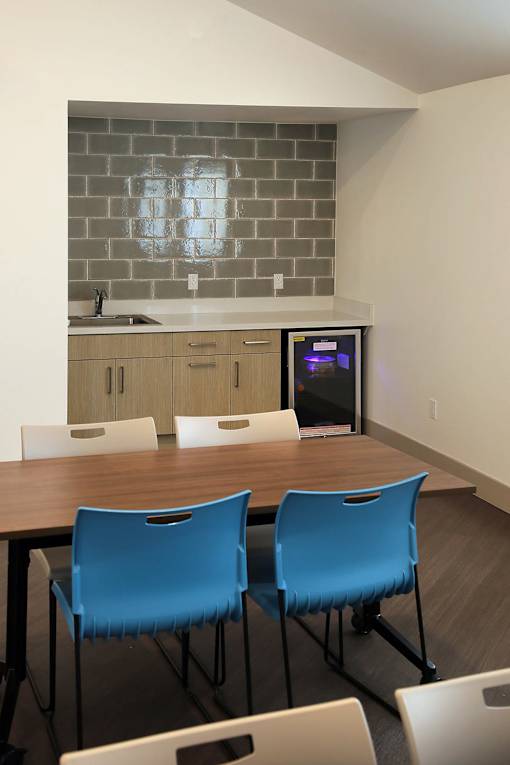 A kitchen with a table and chairs.
