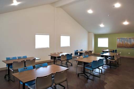 A room with tables and chairs and windows.