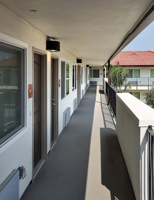 A long hallway with a black floor and white walls.