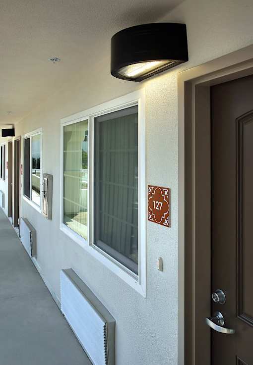 A hallway with a brown door and a sign that says 127.