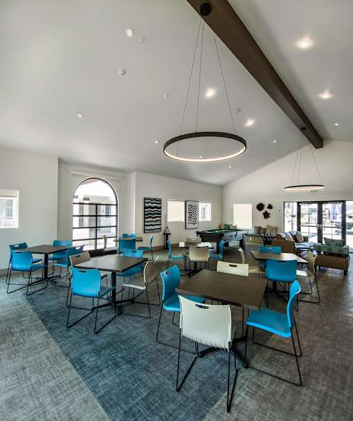 A large room with tables and chairs and a carpet.