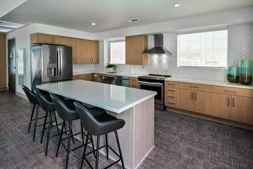 A modern kitchen with a large island and bar stools.