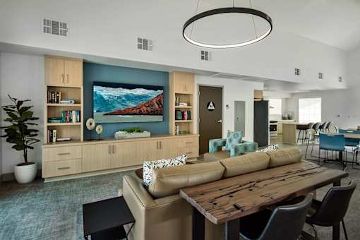 A modern living room with a large painting, a wooden table, and a couch.