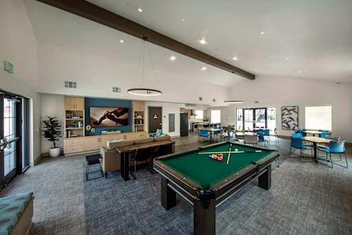 A room with a pool table and a green pool table cloth.