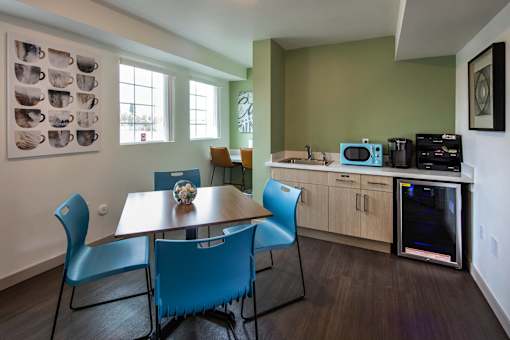 A kitchen with a table and chairs.