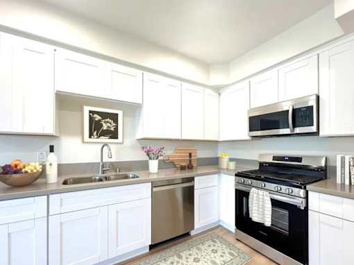 A kitchen with white cabinets and a black oven.