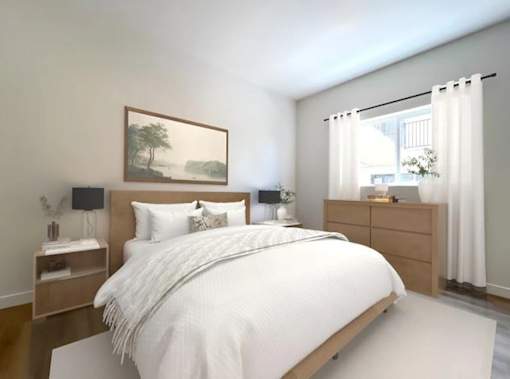 A bedroom with a large bed, a nightstand, and a painting on the wall.