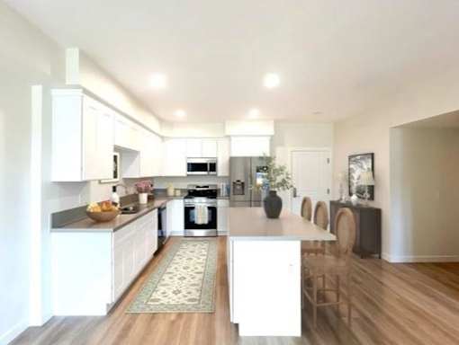 A modern kitchen with white cabinets and a center island.