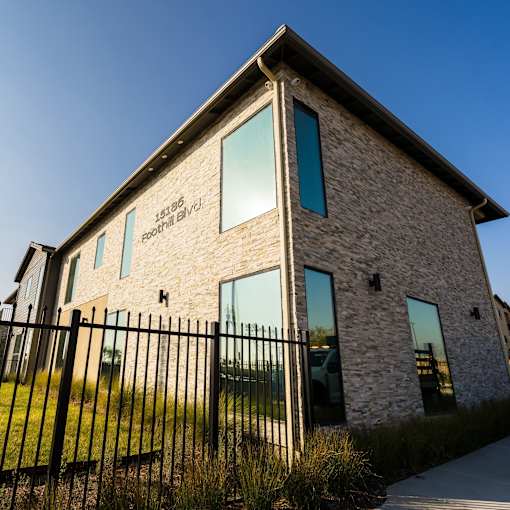 A stone building with a black fence in front.