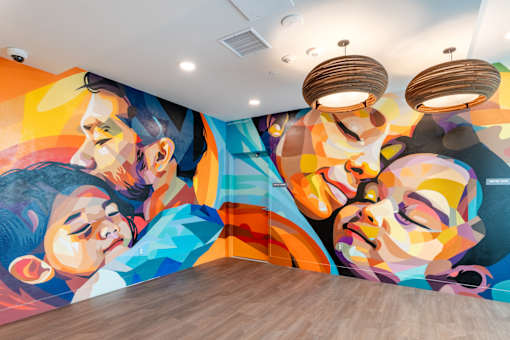 A colorful mural of a man and a woman's faces on a wall.
