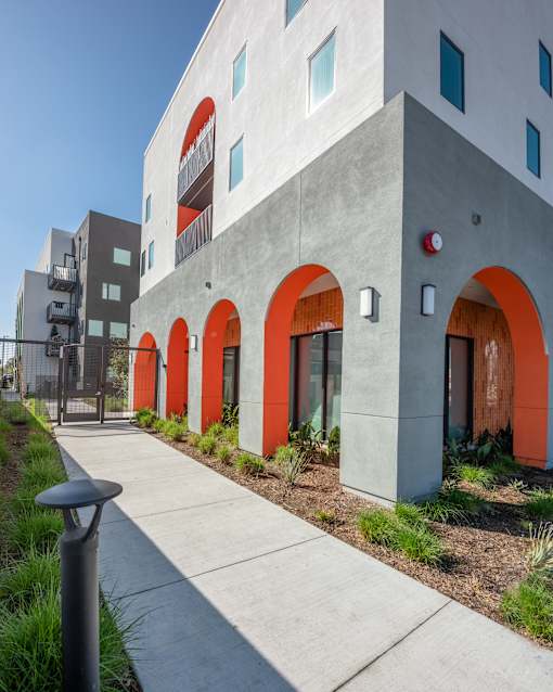 A modern building with orange arches and a concrete facade.