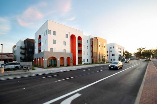 A modern building with white and orange accents sits on a street corner.