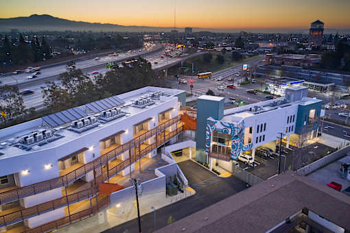 A sunset view of a cityscape with a large building in the foreground.