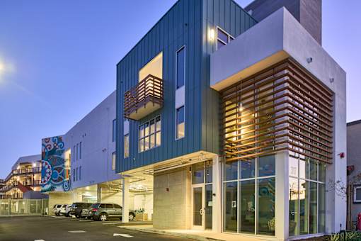 A modern building with a blue and white exterior and a wooden slatted wall.