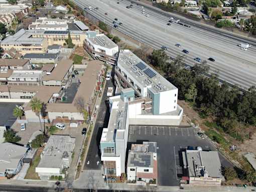 A highway runs through a city with buildings on either side.