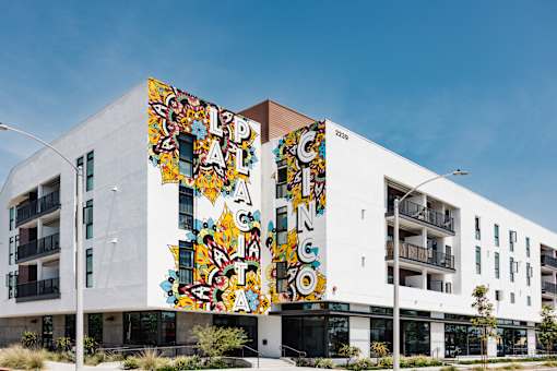 A white building with a colorful mural on the side.