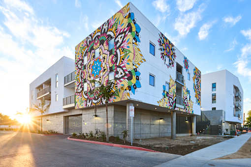 A white building with a colorful mural on the side.