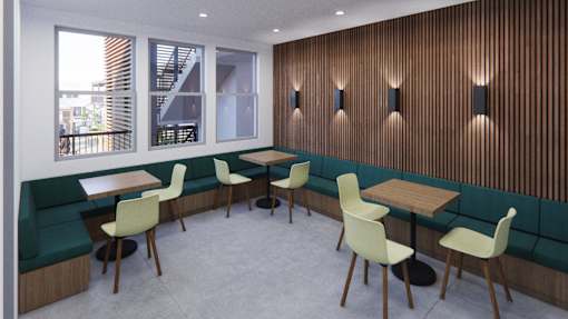 A room with a wooden wall and chairs around a table.