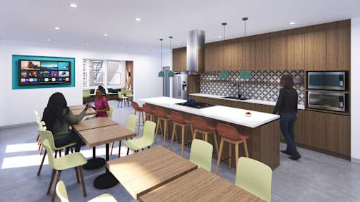 A woman is sitting at a table in a modern kitchen.