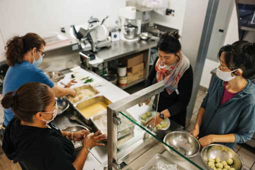 Four women are working in a kitchen.