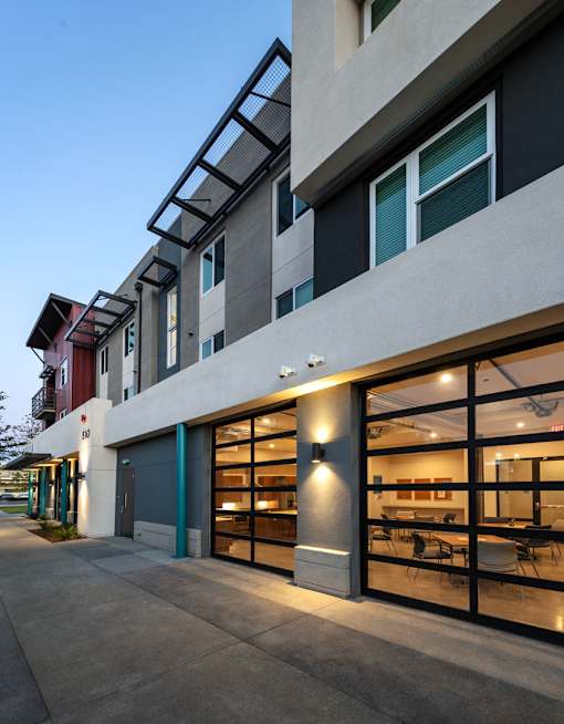 A modern building with a glass entrance and a balcony.