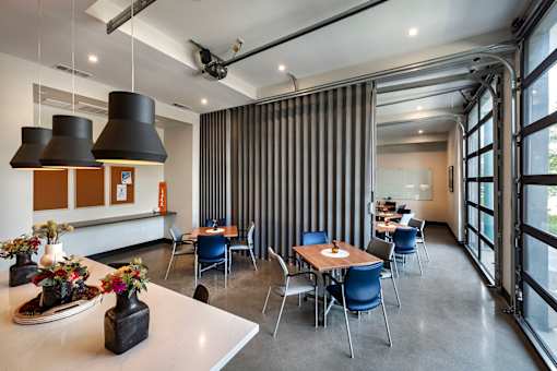 A modern dining room with a long table and chairs.