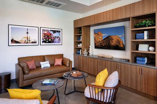 A living room with a brown couch, a coffee table, and a large painting on the wall.
