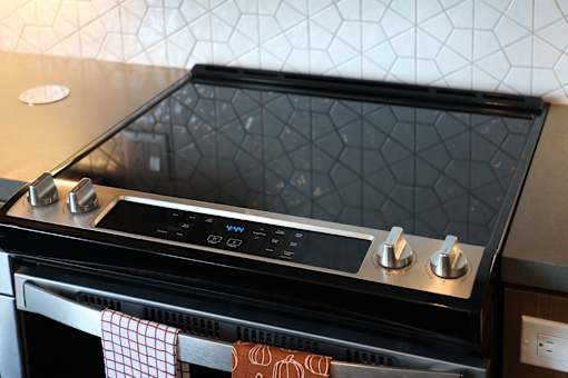 A black oven with a digital display and knobs on top.