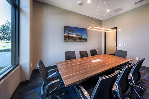A conference room with a long table and chairs.