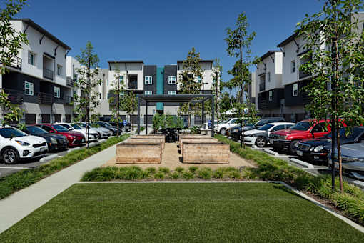A parking lot with cars and apartment buildings in the background.