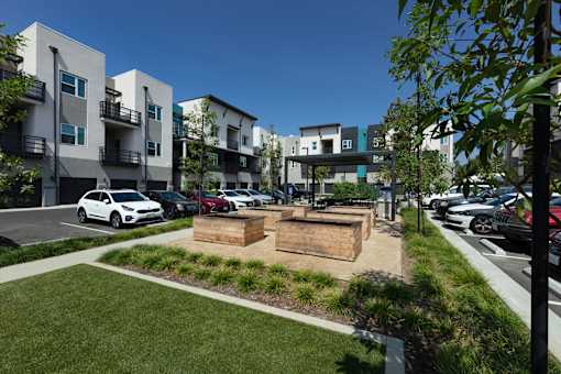 A modern apartment complex with a parking lot in front.