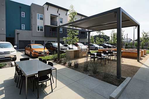 A patio with a table and chairs under a canopy.