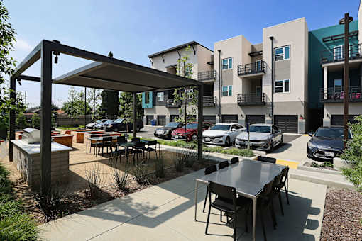 A patio with a table and chairs is surrounded by apartment buildings.