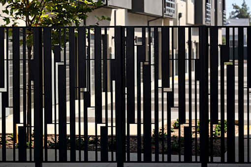 A black fence in front of a building.