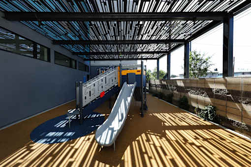 A skateboarding ramp is in a room with a blue ceiling.