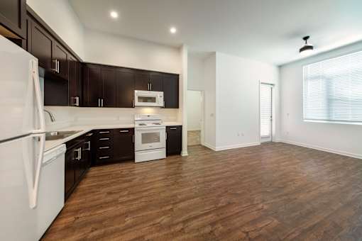 A kitchen with dark brown cabinets and white appliances.