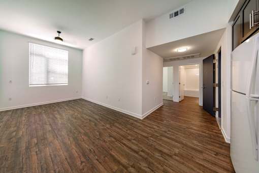 A room with wooden flooring and white walls.
