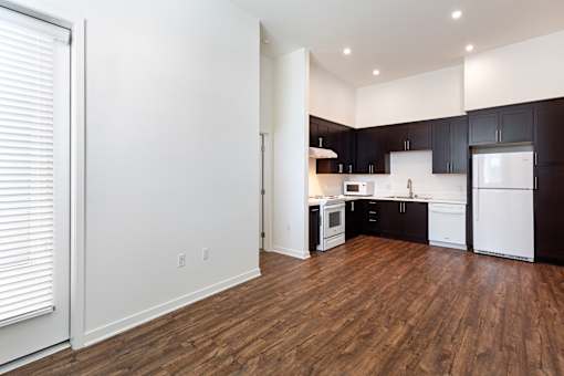 A kitchen with white appliances and black cabinets.