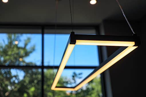 A modern light fixture is hanging from the ceiling.