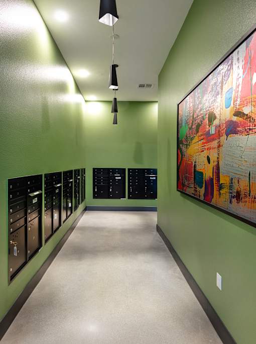 A hallway with a green wall and a painting on the wall.