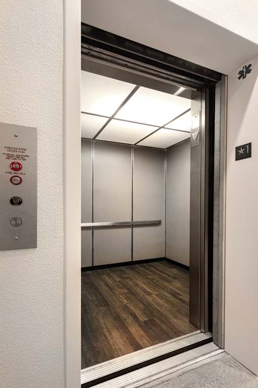 A metal elevator door with a sign on the wall.