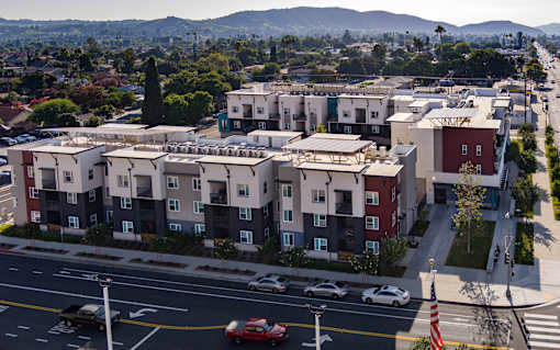 Apartment complex with cars parked in front.