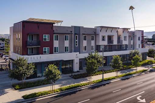 A modern apartment complex named Villa sits on a street corner.