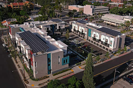 A parking lot is in front of a building with a lot of windows.