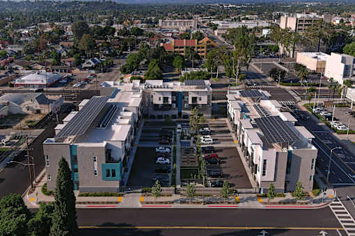 A parking lot is in front of a building with a blue door.