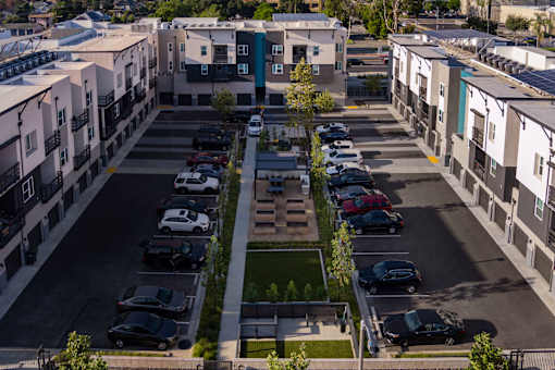 A parking lot with cars and apartment buildings.