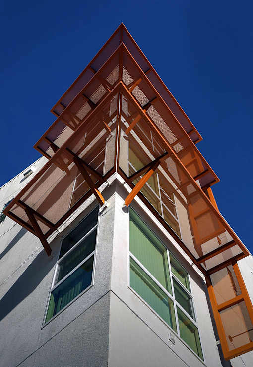 A building with a white facade and a brown roof.